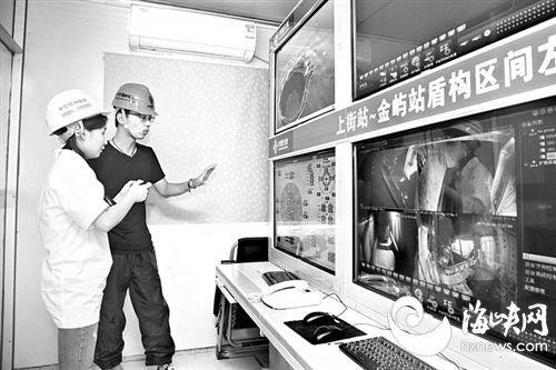 工作人员向海都记者介绍施工实时监控情况(左)