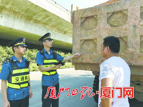 执法人员抓查污染路面的土方车。