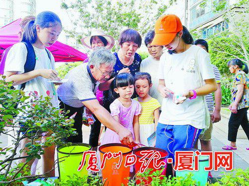 垃圾分类夏令营学员通过互动游戏,向居民宣导垃圾分类知识。(本报记者 吴海奎 摄)