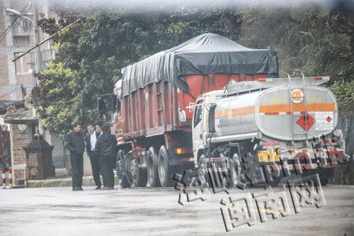 “闽D83058”油罐车在路边加油，两车司乘人员边加油边抽烟