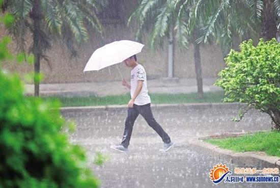 市民雨中出行。陈理杰 图