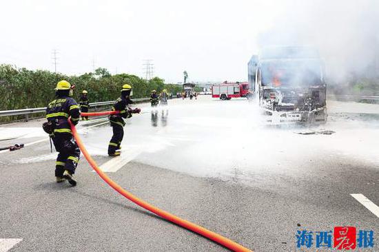 17日中午,一辆半挂车自燃,消防官兵在扑火。通讯员 陈远万 摄