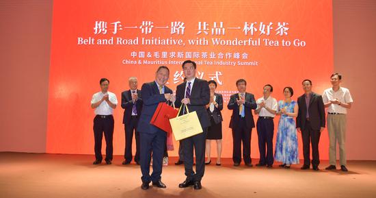 毛里求斯副总理代表、毛里国家银行IBM董事长 Li Kwong Wing 李基昌先生与八马茶业董事长王文礼互赠茶礼