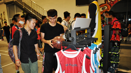 图注:现场人员在贵人鸟品牌展区选购最新运动装备