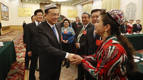 李克强新疆团审议带花帽 和每位代表握手