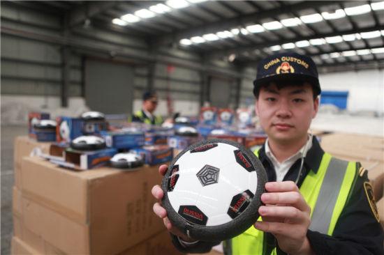 图为宁波海关关员正在查看侵犯“RUSSIA 2018”商标权的电动足球 张佐 摄