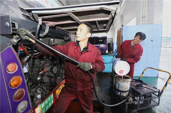 图为车辆加注防冻液。董美巧摄