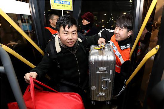 图为金?#39057;?#20026;上车乘客搬运行李。 董美巧 摄