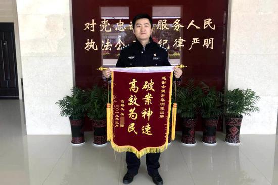 图为:女子新车被盗民警破案追赃,送锦旗?#34892;?#26446;警官快速破案。 牛伟 摄