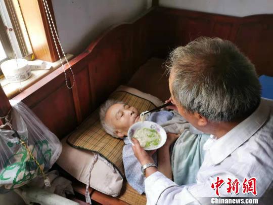 图为裘然安照顾周夏奶。 陈琼 摄