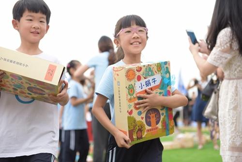 (开学典礼上,阅读盒子是孩子们的入学礼物。)
