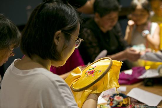 非遗爱好者在传承人的教授下学习鞋面绣制。陈云松 摄