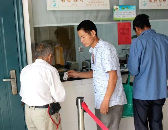 图为娄逢理帮老人挂号