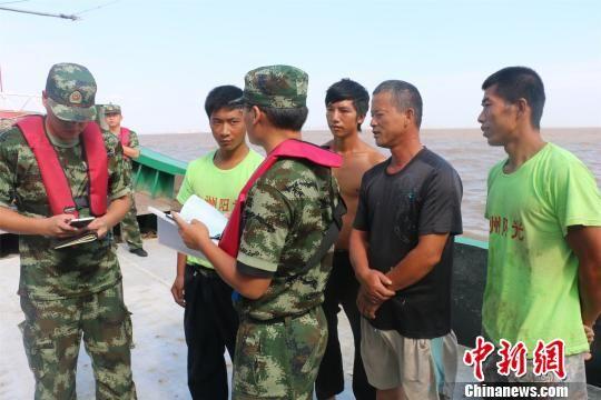 图为:官兵正在核实人员身份。 何蒋勇 摄