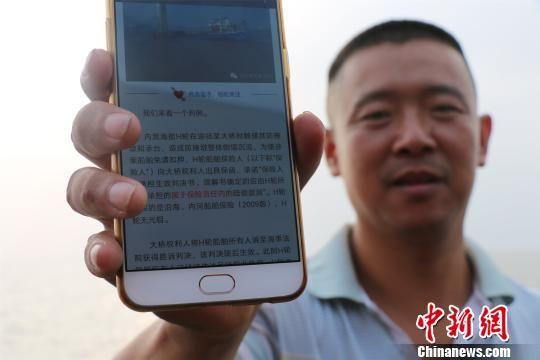 图为:渔民在微信里学海上避碰规则。 何蒋勇 摄