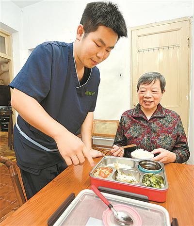 送餐人员将饭菜送到钱美英老人家里。