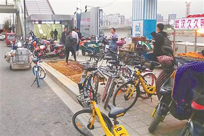 昨日下午,宁波大学地铁站A出口被共享单车和流动摊贩包围。(傅钟中摄)