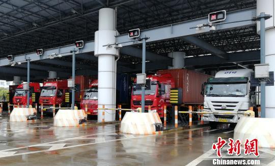图为正准备通过卡口的集卡车。 冯健 摄