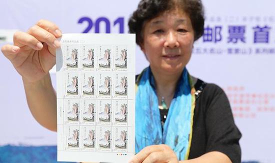 丰子恺的外孙女杨朝婴展示特种邮票《仰之弥高》。浙江新闻客户端 通讯员 章勇涛 摄