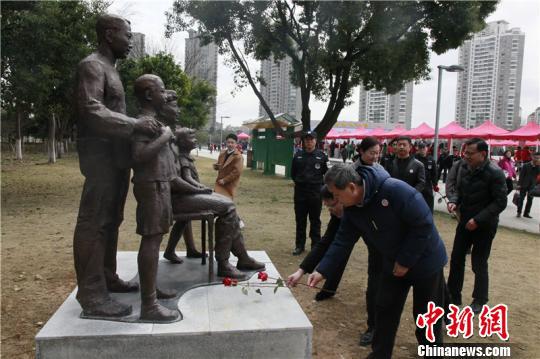 图为人们向雕塑献花 周松 摄