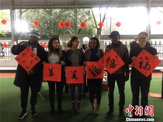 图为外国友人展示书法作品 李佳赟 摄