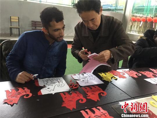 图为外国友人体验剪纸 李佳赟 摄