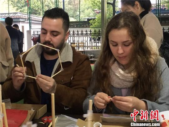 图为外国友人制作灯笼 李佳赟 摄