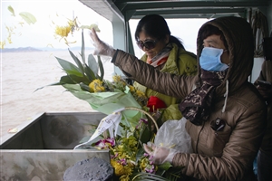 逝者家属把亲人骨灰和鲜花一起撒入大海