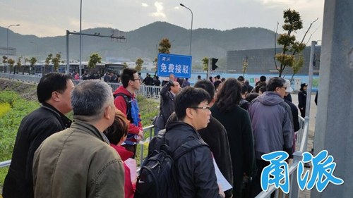 (公交服务人员正在引导免费摆渡线的扫墓客)
