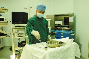 宁大医学院附属医院的男护士李波正在清理手术台。