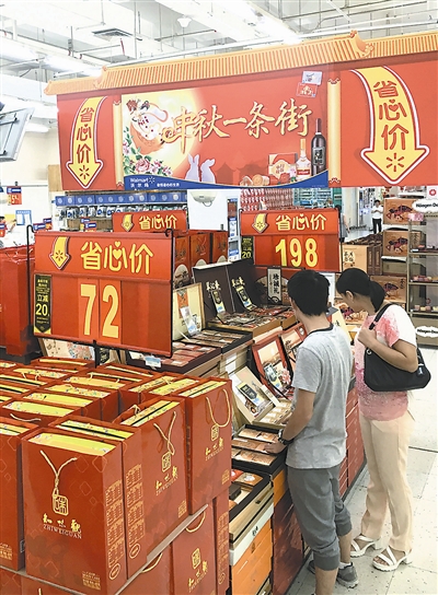 两名顾客在沃尔玛超市选购月饼。