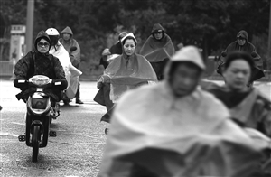 昨天傍晚,雨中赶路的市民 记者 贾东流 摄