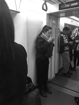 一女孩躲在两节车厢过道内吃饭团