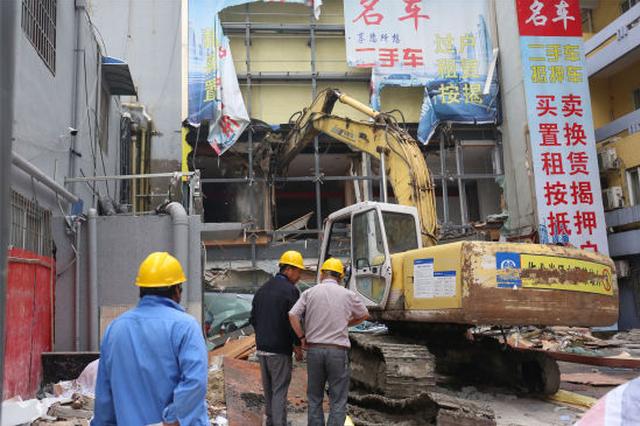 图为:消防联合多部门正在拆除大型违规群租点。
