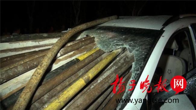 一辆由南向北行驶的汽车追尾撞上一辆装载钢管的拖拉机,几十根钢高清图片