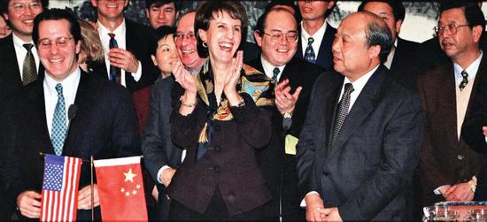 1999年11月15日,中國外經貿部部長石廣生(前右)與美國貿易代表巴爾舍夫斯基(前中),在北京簽署中美關於中國加入世界貿易組織的雙邊協議,這一長達13年的談判終於有了“雙贏”的結果。圖/中新