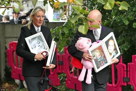  一只粉红猪小妹——小莉娅最喜欢的玩具——和孩子们的照片一起被带到圣保罗教堂。