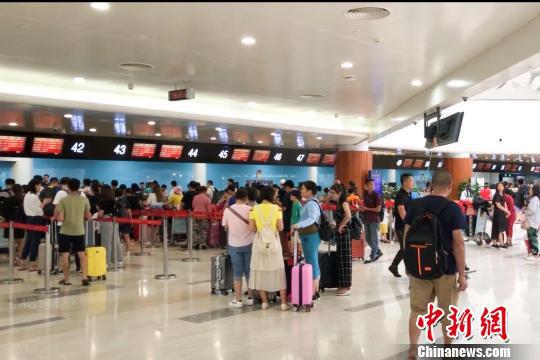 图为旅客在美兰机场航站楼内办理登机手续。美兰机场 供图 图为旅客在美兰机场航站楼内办理登机手续。美兰机场 供图
