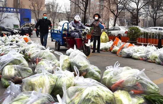 12月31日，西安市科技西路一小区人员为居民运送免费的生活物资（新华社记者 陶明 摄）