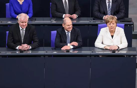 3月14日,德国新一届联邦政府成员在联邦议院全体会议上宣誓就职,德国总理默克尔(右)、德国副总理兼财政部长肖尔茨(中)和内政部长泽霍费尔出席宣誓仪式。新华社记者单宇琦摄