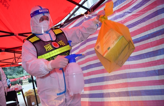 ↑1月7日，西安市雁塔区退役军人志愿突击队队员桑海鑫为核酸检测样本外包装消毒。