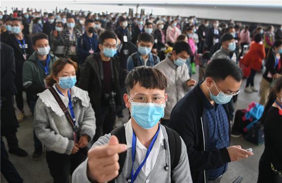 3月19日,务工人员陈安心(前)准备上车。当日,551名湖北荆州务工人员搭乘专列抵达广州,返岗就业。新华社记者 程敏 摄