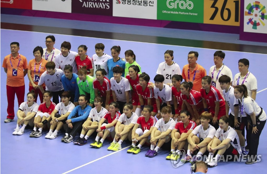 8月14日，韩国队（白色球衣）和朝鲜队（红色球衣）选手在2018雅加达亚运会女子手球预赛前合影留念。（韩联社）