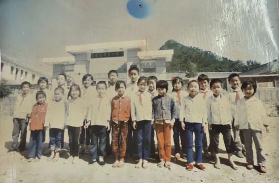 1990年第一批受到青少年发展基金会资助的学生在希望小学门前拍照留念。(翻拍金寨县希望小学资料图) 新京报记者 王飞 摄