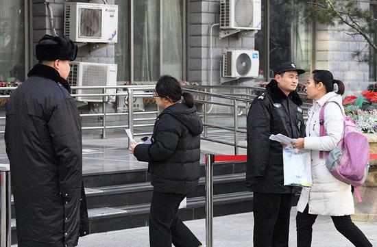 北京联合大学商务学院考场,考生们手持准考证和身份证入场。