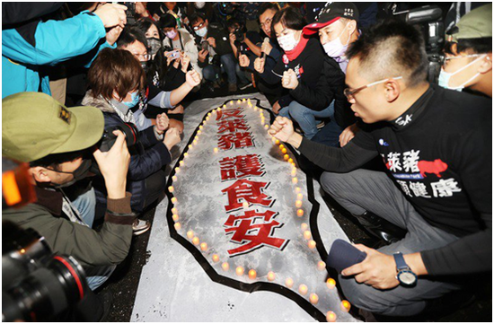“反莱猪护食安”守夜活动23日晚在台“立法院”外举行,国民党主席江启臣带领党籍“立委”点灯,并将烛光放置在“反莱猪护食安”的台湾地图上。图自台湾“联合新闻网”