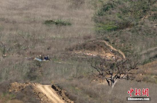 资料图:当地时间1月27日,调查人员在美国加州小城卡拉巴萨斯的山坡上,对直升机坠毁事故进行调查。26日,科比·布莱恩特的私人直升机在卡拉巴萨斯坠毁。中新社记者 刘关关 摄