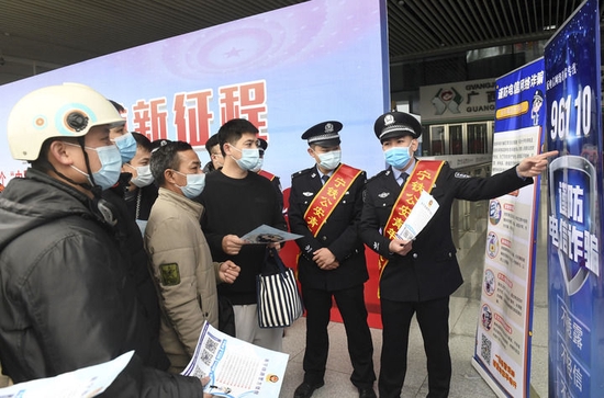 在广西南宁东站,南宁铁路公安处民警向旅客宣传防电信诈骗常识(2022年1月9日摄)。新华社记者 陆波岸 摄