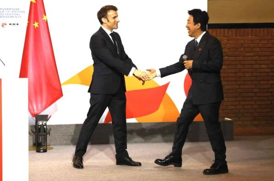 ·马克龙5日参加第17届“中法文化之春”艺术节开幕式时与中国演员黄渤互动。