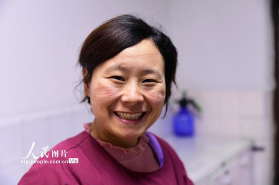 面对压力与疲惫,脱下口罩的90后选择笑容以对。胡悦建/人民图片